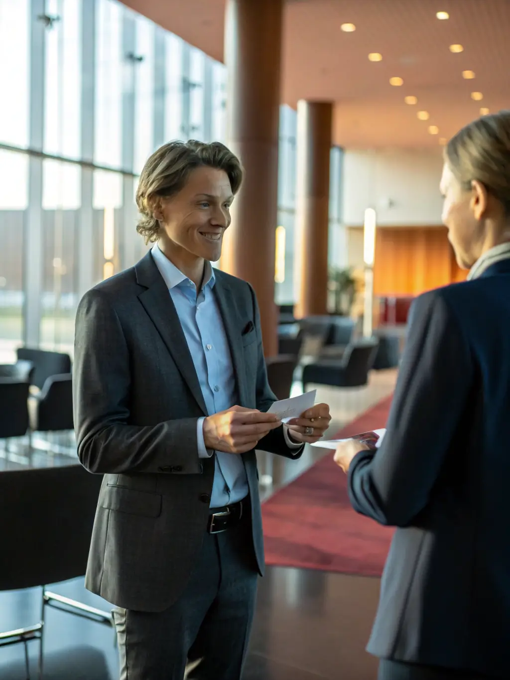 A diverse group of professionals networking at a ProConnect conference, exchanging business cards and engaging in conversation.